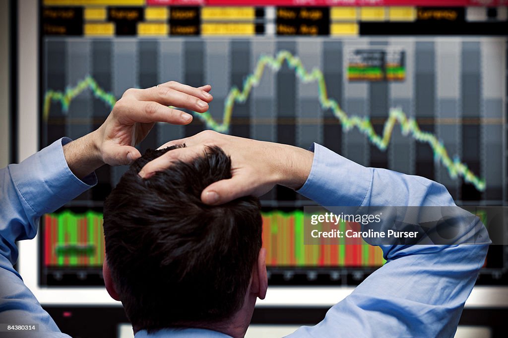 Trader watching stocks crash on screen