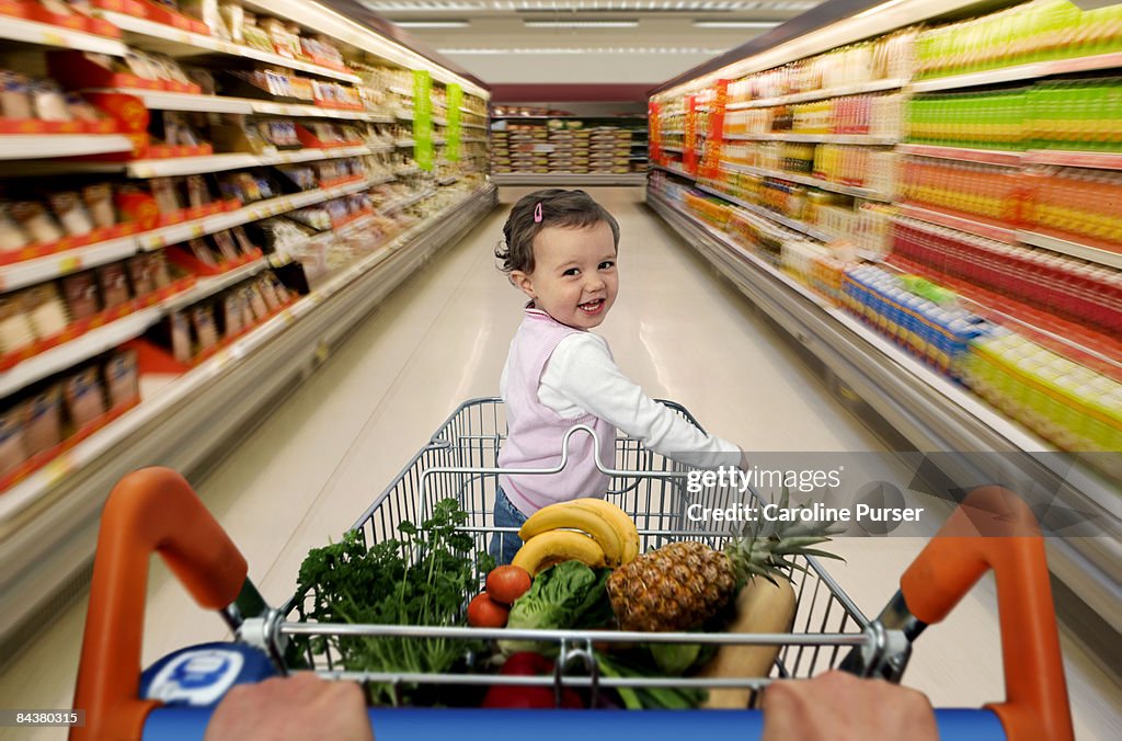 Toddler in trolley in supermarket motion blur
