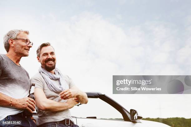 portrait of two mature adult men taking a break from driving - drink driving stockfoto's en -beelden