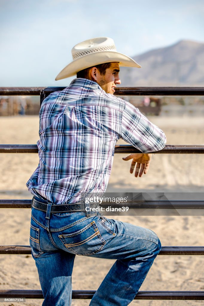 Cowboy Leaning on a Fence