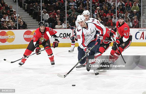 Matt Bradley the Washington Capitals stickhandles the puck against Jason Smith and Peter Regin of the Ottawa Senators at Scotiabank Place on January...