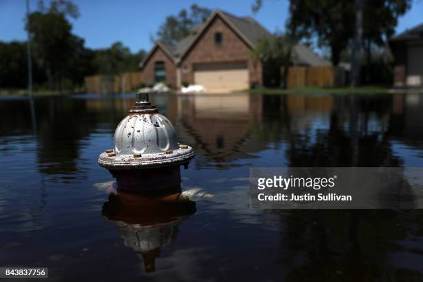 The top of a fire hydrant sticks out of floodwaters in front of a home on September 7, 2017 in Richwood, Texas. Over a week after Hurricane Harvey...