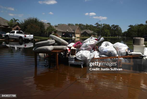 Damaged furniture and personal belongings sit in front of a flooded home on September 7, 2017 in Richwood, Texas. Over a week after Hurricane Harvey...