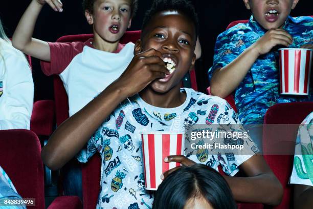 group of children enjoying a movie at the cinema - get out 2017 film stock-fotos und bilder