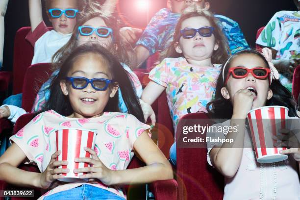 group of children enjoying a movie at the cinema - children theatre foto e immagini stock