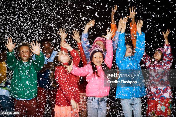 group of children dressed in winter coats having fun in the snow - girl in winter coat studio stock pictures, royalty-free photos & images