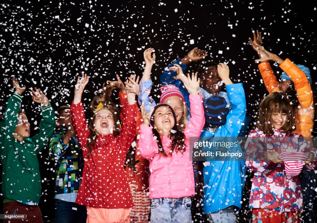 Group of children dressed in winter coats having fun in the snow