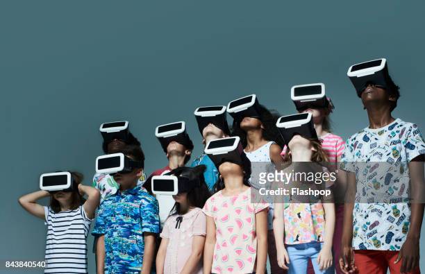 group of children wearing virtual reality headsets - cyberspace stockfoto's en -beelden