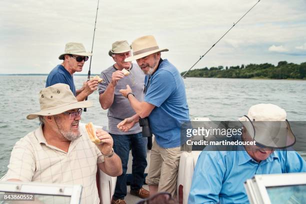 Five active seniors brothers on a fishing trip on a boat.