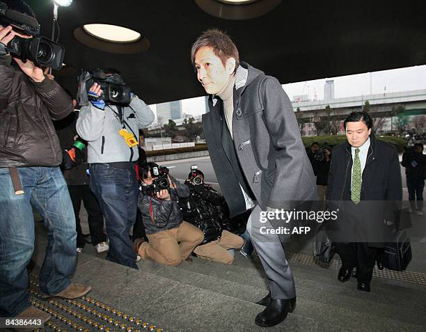 Tetsuya Komuro, one of the most successful producers in Japan's pop music history arrives at the Osaka district court on January 21, 2009 for his...