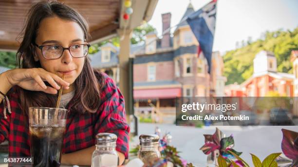 die hübsche 16-jährige teenager mädchen essen in der straße cafee in jim thorpe, poconos region, pennsylvania - jim thorpe pennsylvania stock-fotos und bilder