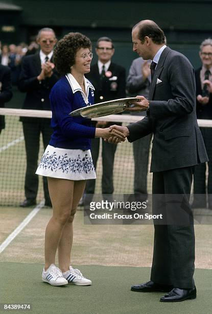 Billie Jean King of the USA is presented with the championship trophy for women's singles of the Wimbledon Lawn Tennis Championships after defeating...