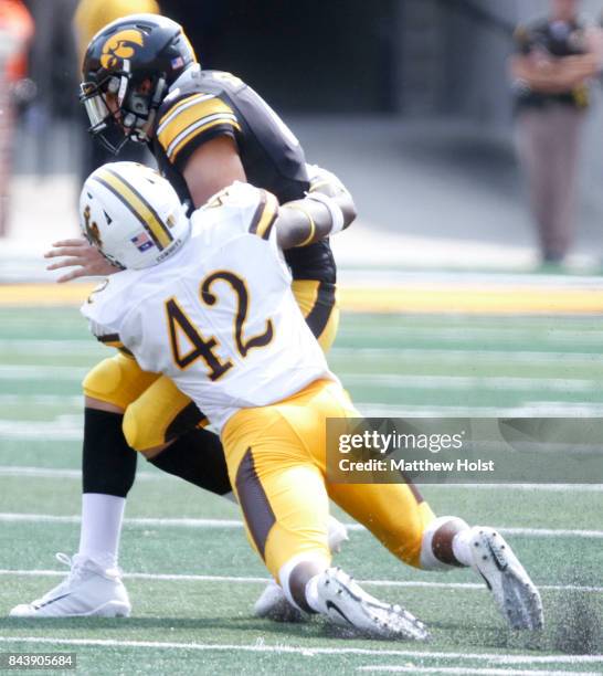 Quarterback Nathan Stanley of the Iowa Hawkeyes is sacked during the third quarter by defensive end Kevin Prosser of the Wyoming Cowboys on September...