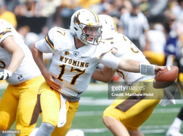 Quarterback Josh Allen of the Wyoming Cowboys hands off the ball in the fourth quarter against the Iowa Hawkeyes, on September 2, 2017 at Kinnick...