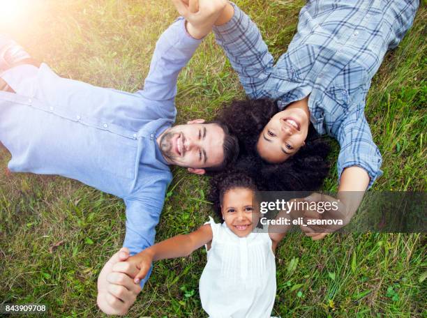 family laying in grass together - lying on back photos stock pictures, royalty-free photos & images