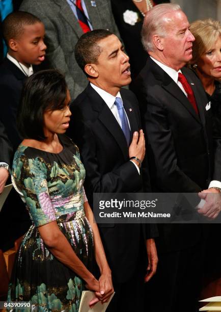 President Barack Obama places his hand ove his heart while singing the National Anthem during the National Prayer Service at the Washington National...