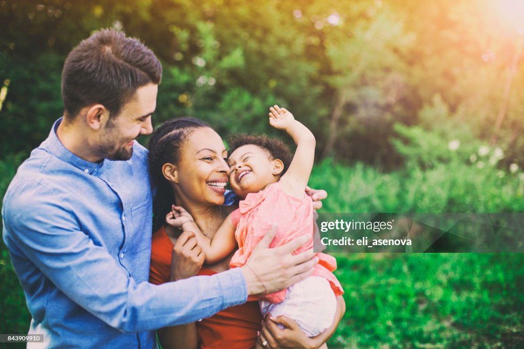 Familia caminando en campo llevando jóvenes bebé niña