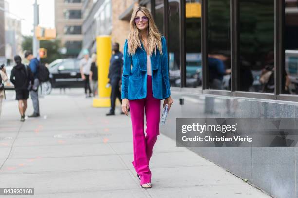 Martha Graeff seen wearing blue velvet blazer, pink pants, sunglasses, transparent clutch in the streets of Manhattan outside Desigual during New...