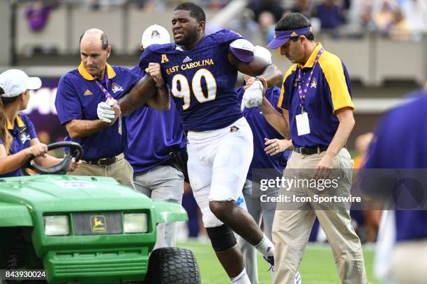 Defensive end Randall Anderson of the East Carolina Pirates is taken off the field in a cart after injuring his knee during a game between the James...