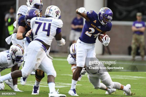 Running back Derrell Scott of the East Carolina Pirates is tackled during a game between the James Madison Dukes and the East Carolina Pirates on...