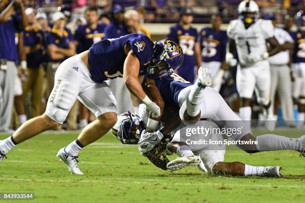 Wide receiver Tahj Deans of the East Carolina Pirates is tackled during a game between the James Madison Dukes and the East Carolina Pirates on...