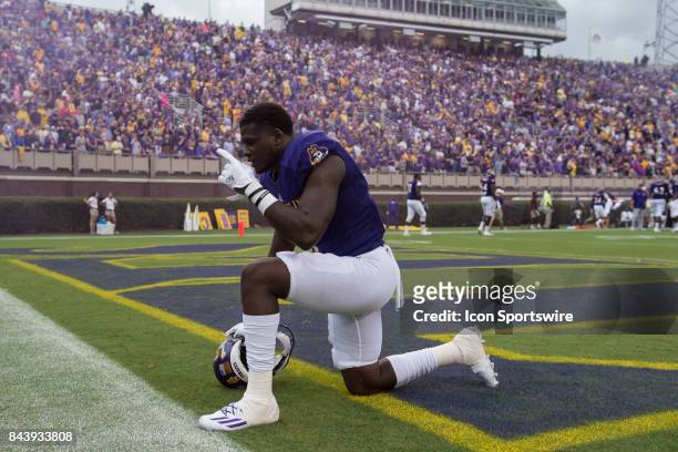 Defensive back Tim Irvin of the East Carolina Pirates prays before a game between the James Madison Dukes and the East Carolina Pirates on September...