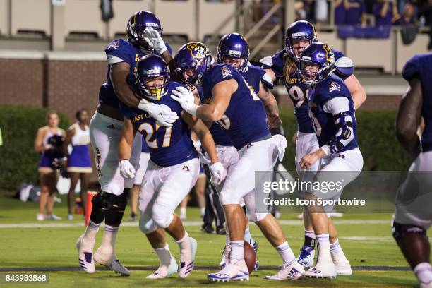 Running back Darius Pinnix of the East Carolina Pirates celebrates with teammates after scoring a touchdown during a game between the James Madison...