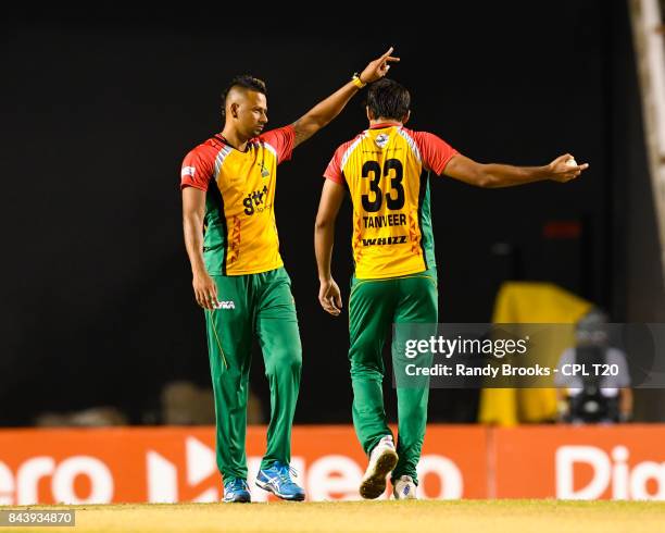 In this handout image provided by CPL T20, Rayad Emrit and Sohail Tanvir of Guyana Amazon Warriors set the field during Eliminator 2 of the 2017 Hero...