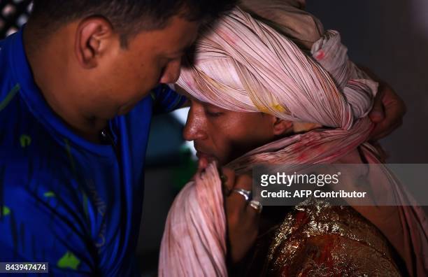 This photograph taken on September 3, 2017 shows Nepali Lakhe dancer Laxman Ranjit being helped into his costume before performing the "Lakhe" dance...