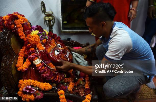 This photograph taken on September 3, 2017 shows Nepali Lakhe dancer Laxman Ranjit cleaning a mask before performing the "Lakhe" dance in Kathmandu....