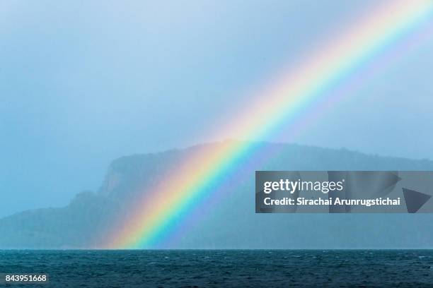 rainbow in the rainy sea - bruny island stock pictures, royalty-free photos & images