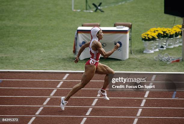 Florence Griffith Joyner of the USA competes during the 100M race during the 1988 Summer Olympic Games at the Seoul Olympic Stadium in Seoul, South...