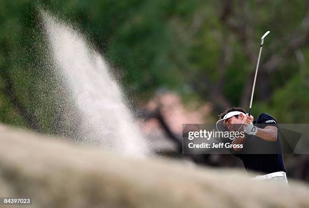 Ryuji Imada of Japan hits out of a fairway bunker on the 18th hole during the first round of the Bob Hope Chrysler Classic at the Nicklaus course at...