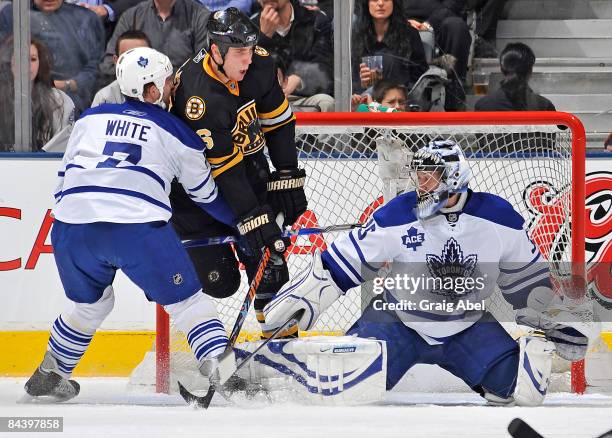 Ian White of the Toronto Maple Leafs battles with Blake Wheeler of the Boston Bruins in front of goalie Vesa Toskala of the Maple Leafs during game...