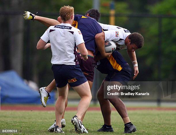 Ashton Sims is picked up by the defence during the Brisbane Broncos Rugby League team training session on January 22, 2009 at the University of...