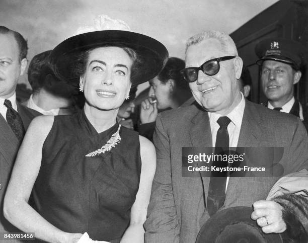 Joan Crawford et son mari Alfred Steele arrivant à la gare de Waterloo à Londres, Royaume-Uni, le 24 juillet 1956.