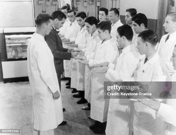 Le docteur Leon Jablow inspectant les mains et ongles des apprentis bouchers à la Food Trades Vocational High School à New York, Etats-Unis, en 1938.