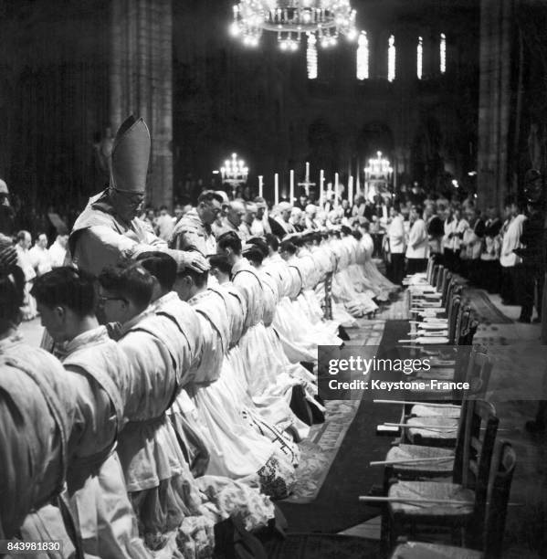 Cérémonie de l'imposition des mains lors de l'ordination de 68 nouveaux prêtres en la cathédrale Notre-Dame à Paris, France, le 20 avril 1946.