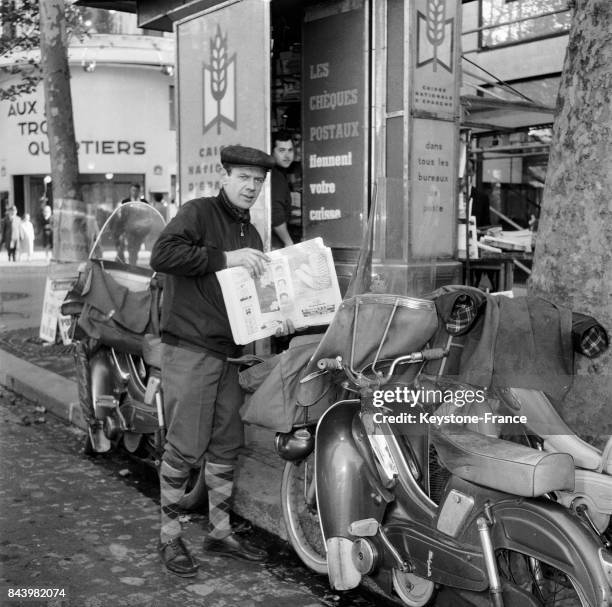 Livraison de journaux en mobylette à un kiosque à journaux à Paris en France, en 1964.