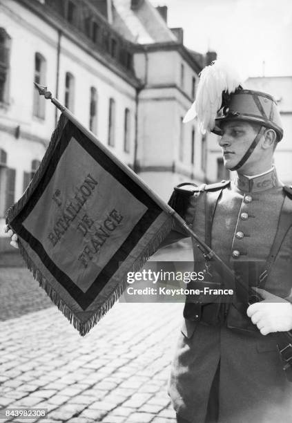 Cadet, élève-officier de l'école militaire de Saint-Cyr, portant le fanion de son école à Saint-Cyr-l'Ecole en France, le 6 mai 1936.