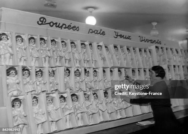 Des poupées alignées dans une fabrique de poupées à l'approche des fêtes de Noël le 22 novembre 1932 en France.