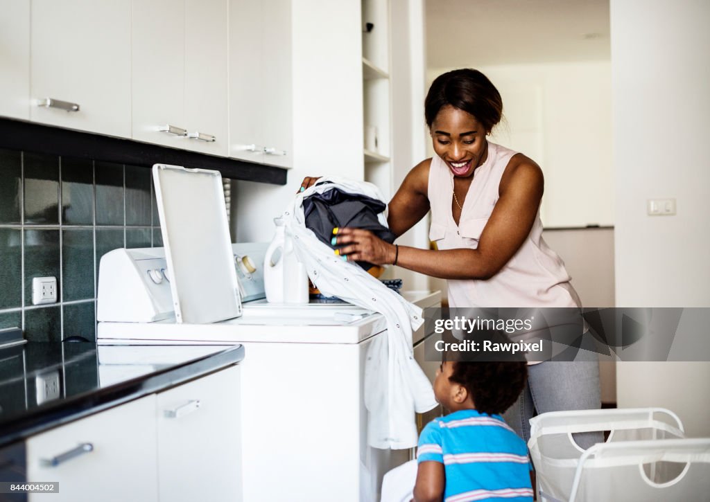 非洲人後裔的孩子説明媽媽洗衣服