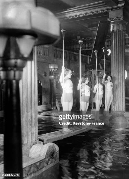 Des baigneuses prêtes à affronter leurs rivales en robe du soir lors des joutes lyonnaises au Lido le 8 décembre 1932 à Paris, France.