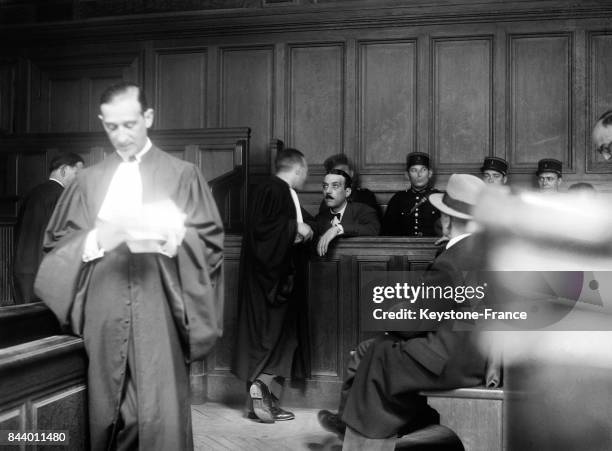 Ex-inspecteur de police Pierre Bonny s'entretient avec son avocat maître Aaron pendant l'audience à Paris, France, le 16 octobre 1935.