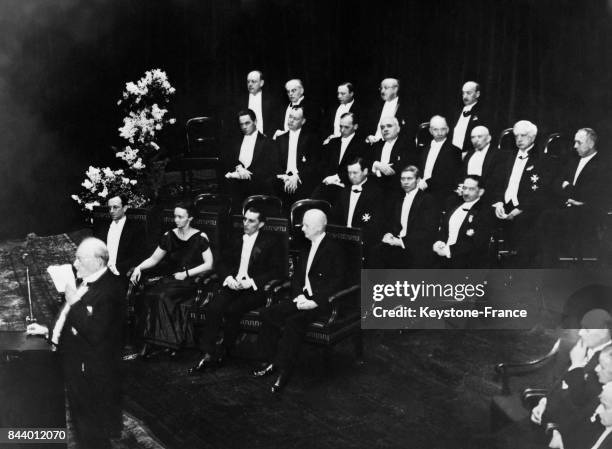 Les lauréats de 1935 réunis pendant la cérémonie, au premier plan, de gauche à droite, Monsieur Chadwick, Madame et Monsieur Joliot-Curie et le...