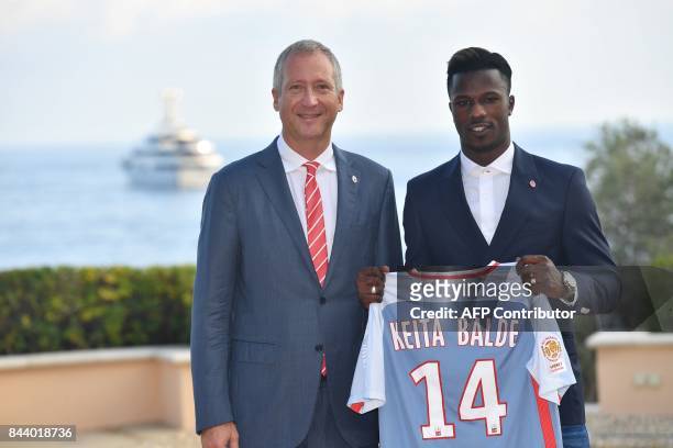 Monaco football club's newly recruited Spanish forward Keita Balde poses with his new jersey next to Monaco's Russian Vice-President Vadim Vasilyev...