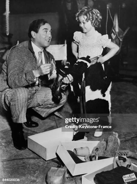 Acteur Leo Carrillo offre à Shirley Temple un équipement complet de cow-boy, aux Etats-Unis le 6 décembre 1935.