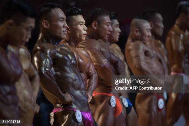 In this photo taken on September 2 bodybuilders compete in the 2017 NABBA WFF Asia Seoul Open Bodybuilding Championship in Seoul. / AFP PHOTO / Ed...