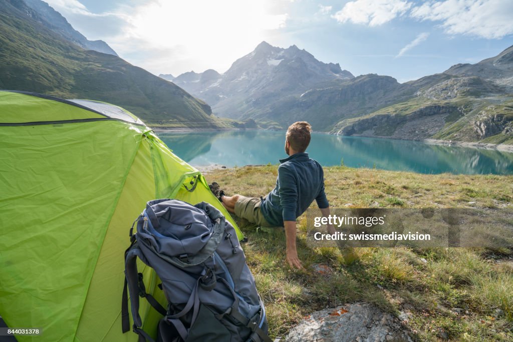 Mâle de randonneur reposant à côté du camping, vue sur le lac