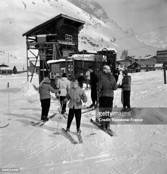 Groupe de skieurs au pied de la remontée mécanique, au Val d'Isère, France en février 1956.